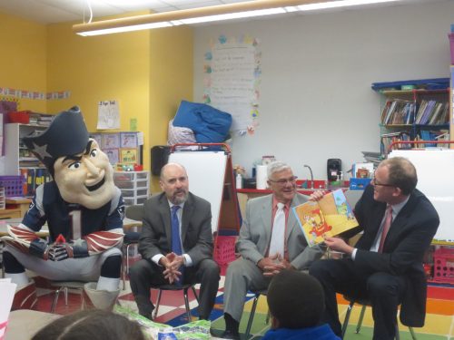 New England Patriots Mascot Pat Patriot, State Representatives Paul Brodeur and Paul Donato, and State Senator Jason Lewis read to a class of first-graders.